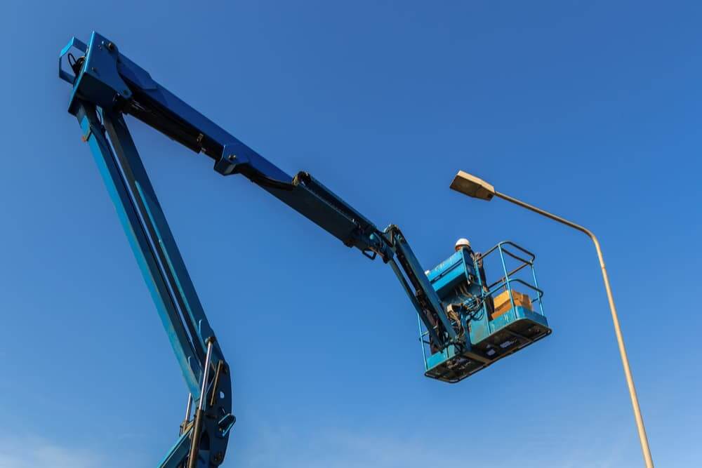 Homem consertando poste de luz